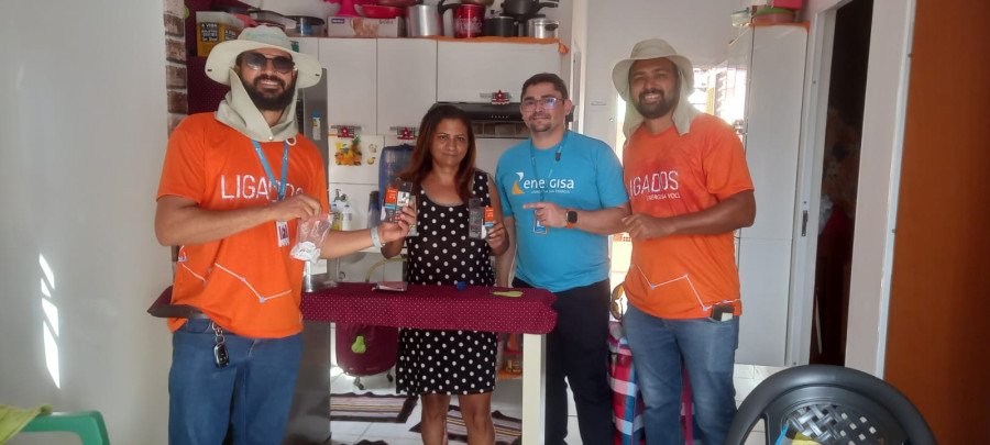 Equipe da Energisa trocando lâmpada e entregando protetores de tomada (Foto: Divulgação)