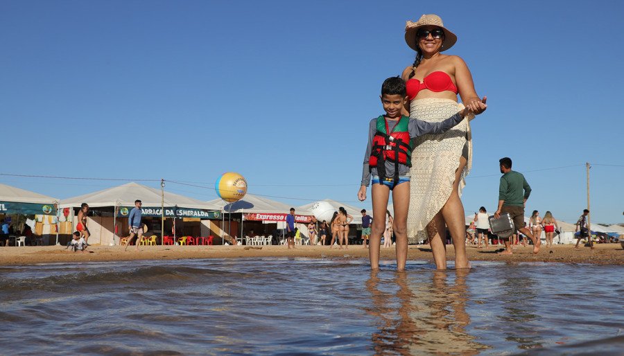 Patrícia Melo e seu filho Samuel brincando na área demarcada para banho, com vigilância constante dos guarda-vidas (Foto: Adilvan Nogueira)