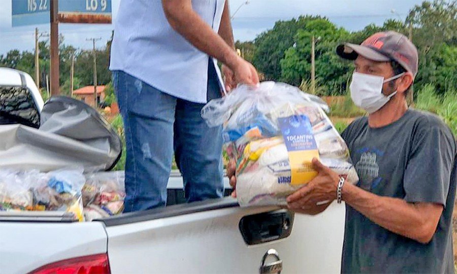 Alexandre Oliveira dos Santos recebendo a cesta bÃ¡sica