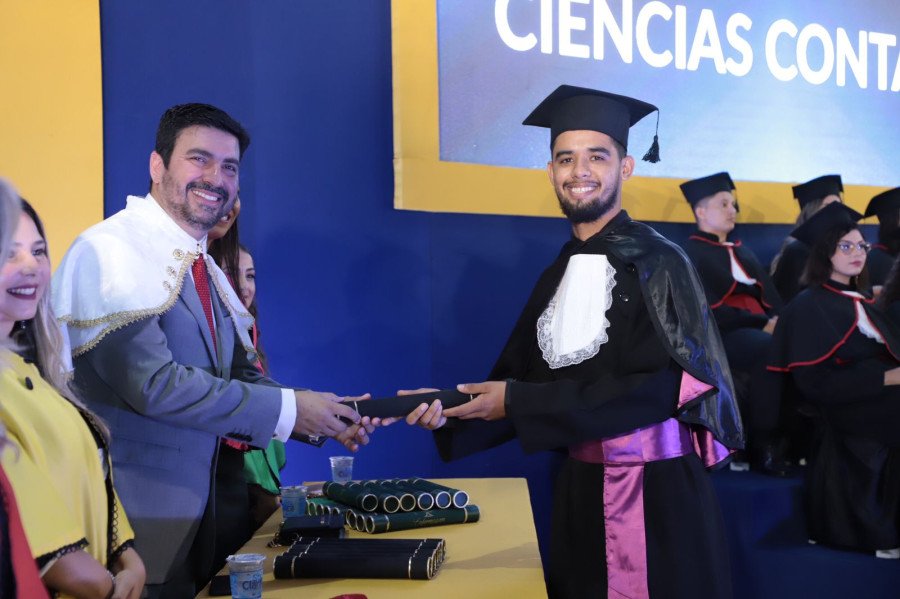 O bacharel em Ciências Contábeis Marco Lira recebendo de forma simbólica seu diploma das mãos do reitor Augusto Rezende