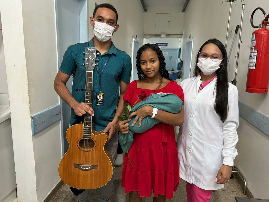 A paciente Keiti juntamente com seu bebê Maurício e os integrantes do projeto (Foto: Ananda Portilho)