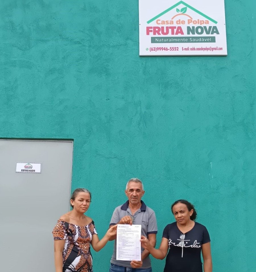Assentados e associados da ASBB seguram o registro de regularização sanitária da Casa de Polpa Fruta Nova (Foto: Divulgação)